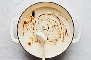 vanilla being stirred into a pot of melted butter and melted marshmallows