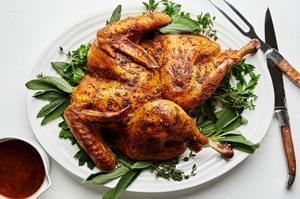 A Roast Spatchcocked Turkey seasoned with sage, thyme, turmeric, garlic, pepper and paprika on a serving platter