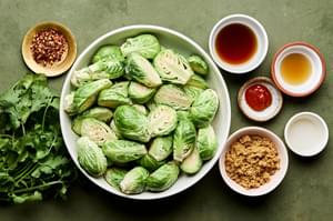 brussels sprouts, fish sauce, brown sugar, sriracha, red pepper flakes, sesame oi, rice vinegar, cilantro and min in bowls
