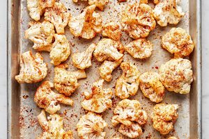 cauliflower florets tossed with olive oil, salt, garlic powder, smoked paprika and red pepper flakes on a baking sheet