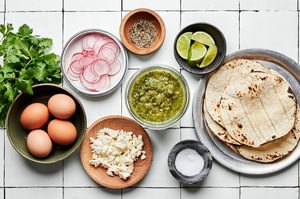 eggs, corn tortillas, salsa verde, salt, pepper, cotija, radishes, cilantro and lime wedges in prep bowls