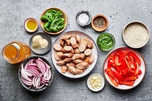italian chicken sausage, rice, peppers, onion, basil, chicken stock and spices in prep bowls to make a sausage & rice skillet