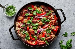 Homemade sausage and rice skillet made with peppers, onions, basil and topped with pesto