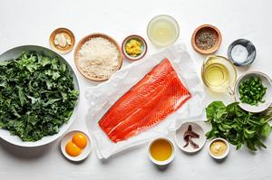 salmon filet, kale, serrano peppers, parmesan, anchovies, egg yolks and mint in prep bowls