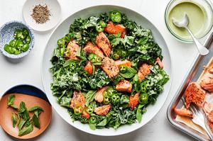 Serrano Mint Kale Salad with Salmon garnished with serrano peppers and parmesan in a serving bowl