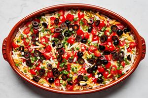 refried beans, sour cream, guacamole, shredded cheese, olives and tomatoes layered in a serving bowl