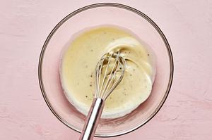 goat cheese dressing being whisked in a bowl made with goat cheese, olive oil, apple cider vinegar, salt, pepper and honey