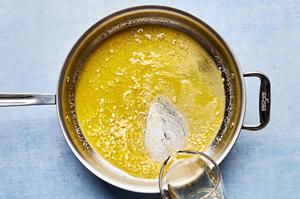 wine being poured into a skillet with olive oil, butter and garlic