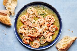 homemade shrimp scampi on a serving plate surrounded by crusty bread