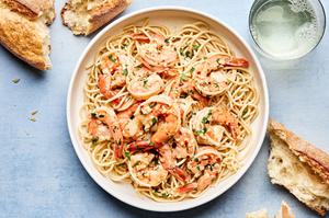 homemade shrimp scampi served over pasta noodles with crusty bread
