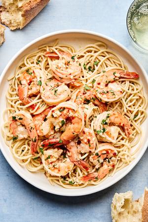 homemade shrimp scampi served over pasta noodles with crusty bread