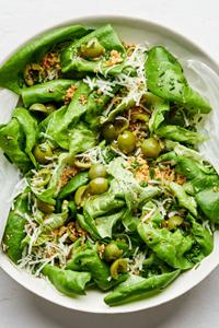 a simple butter lettuce salad with apple cider vinaigrette, olives, breadcrumbs, chives, manchego cheese and ground pepper