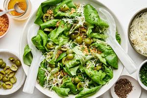 a simple butter lettuce salad with apple cider vinaigrette, olives, breadcrumbs, chives, manchego cheese and ground pepper