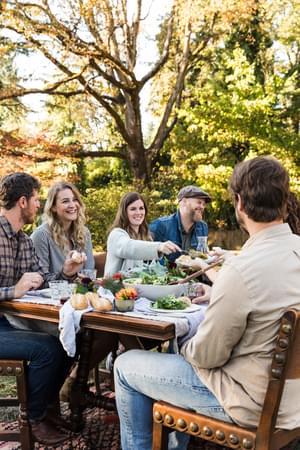people sitting at an outdoor table together enjoying a meal