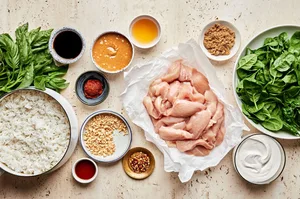 raw chicken, peanut butter, coconut cream, red curry paste, soy sauce, brown sugar, fish sauce, spinach & rice in prep bowls