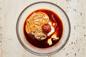 peanut butter, coconut cream, red curry paste, soy sauce, brown sugar, fish sauce & apple cider vinegar being mixed in a bowl