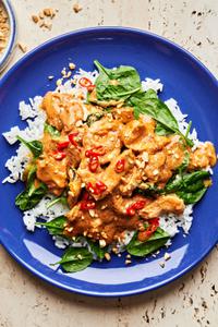 slow cooker swimming rama served on top of white rice topped with crushed peanuts, basil and red chili flakes