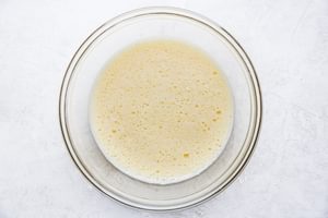6 raw scrambled eggs in a glass mixing bowl