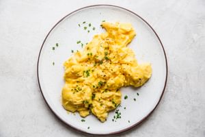 soft scrambled eggs on a plate with chives