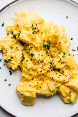 soft scrambled eggs on a plate with chives