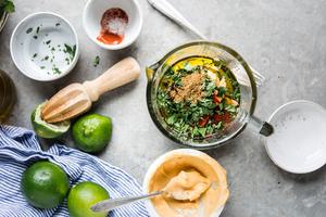 chipotle mayonnaise in a bowl with a spoon with lime, chipotle powder and cilantro