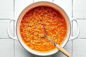 a pot of homemade spaghettiOs made with tomato paste, butter, spices, tomato sauce, chicken stock, cream and parmesan