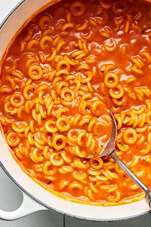 a pot of homemade spaghettiOs made with tomato paste, butter, spices, tomato sauce, chicken stock, cream and parmesan