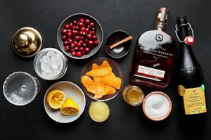 bourbon, apple cider, lemon juice, sparkling wine, cranberries, cinnamon stick, sugar and orange peel in prep bowls