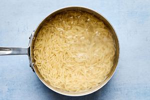 orzo cooking in a pot of boiling water