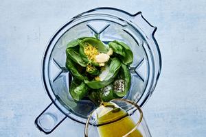 garlic, lemon zest & juice, basil, olive oil, sugar, salt and pepper being combined in a blender to make basil vinaigrette