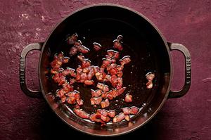 chopped bacon being cooked in a large soup pot
