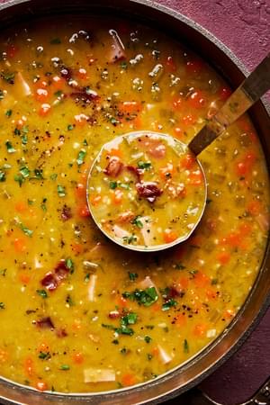 a pot of homemade split pea soup with ham, bacon, celery, carrots, onion, chicken stock and spices