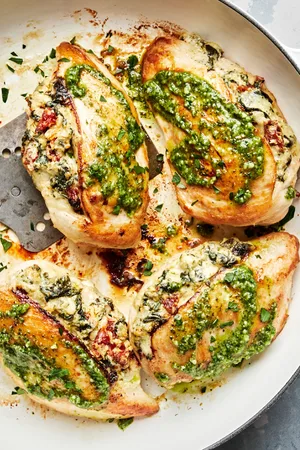 4 chicken breasts stuffed with spinach, garlic, cream cheese, mozzarella & sun-dried tomatoes topped with pesto in a skillet
