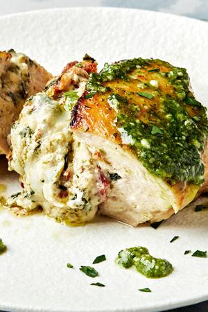 chicken breast stuffed with spinach, garlic, cream cheese, mozzarella & sun-dried tomatoes topped with pesto