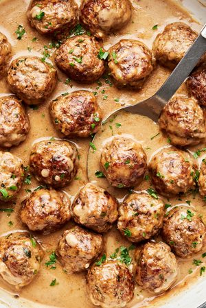 Homemade Swedish meatballs simmering in creamy brown gravy inside a large pot, a delicious comfort food recipe