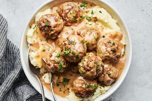 Homemade Swedish meatballs served over creamy mashed potatoes, topped with rich brown gravy and a sprinkle of parsley