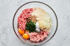 ground beef, ground pork, spices, grated onion, panko and eggs getting mixed in a bowl to make swedish meatballs