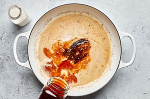 homemade creamy brown gravy being cooked in a pot for swedish meatballs