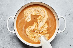 homemade creamy brown gravy being cooked in a pot for swedish meatballs