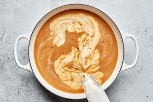 homemade creamy brown gravy being cooked in a pot for swedish meatballs