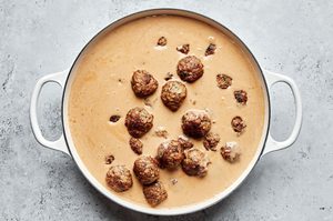 Homemade Swedish meatballs simmering in creamy brown gravy inside a large pot, a delicious comfort food recipe