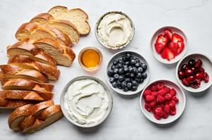 challah bread, fresh berries, honey, greek yogurt and mascarpone in prep bowls to make sweet berry bruschetta