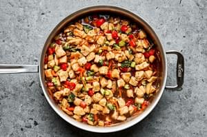 chicken, broccoli, red pepper, and shredded carrots tossed in teriyaki sauce in a skillet