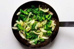 garlic, onion and broccoli in a frying pan with sesame oil