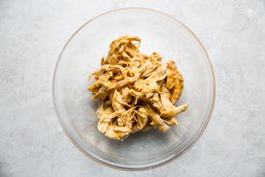 peanut sauce shredded chicken in a bowl