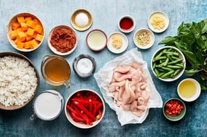 Ingredients laid out on a countertop for making Thai red curry with chicken and vegetables