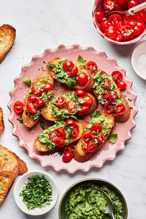 tomato and avocado bruschetta served on crusted garlic bread on a serving platter