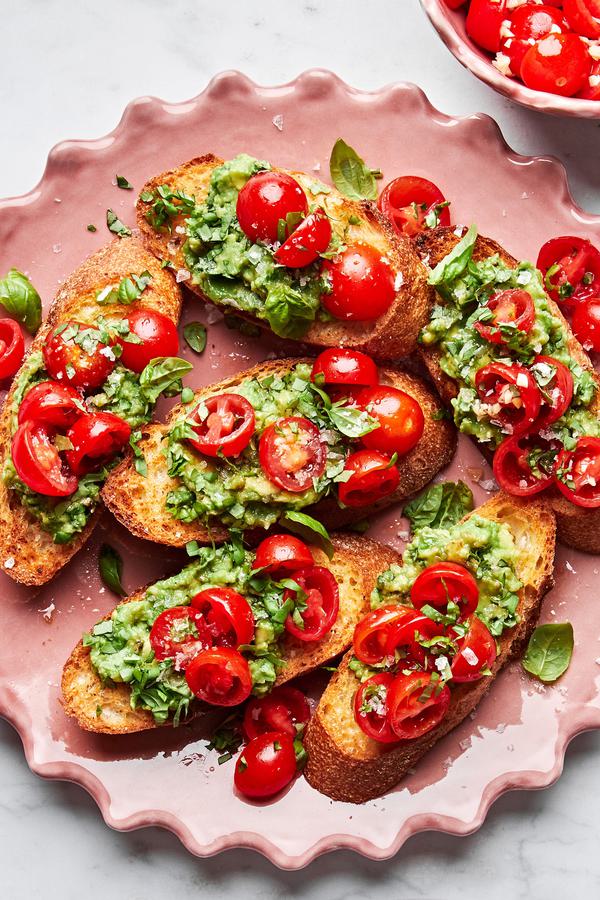tomato and avocado bruschetta served on crusted garlic bread on a serving platter