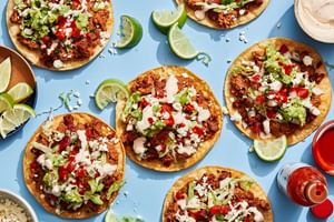 Easy tostadas with chorizo, refried beans, lettuce, cotija, pico de gallo, guac, and lime crema on crispy shells
