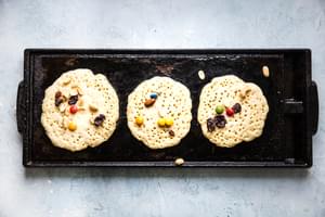 trail mix pancakes on a griddle